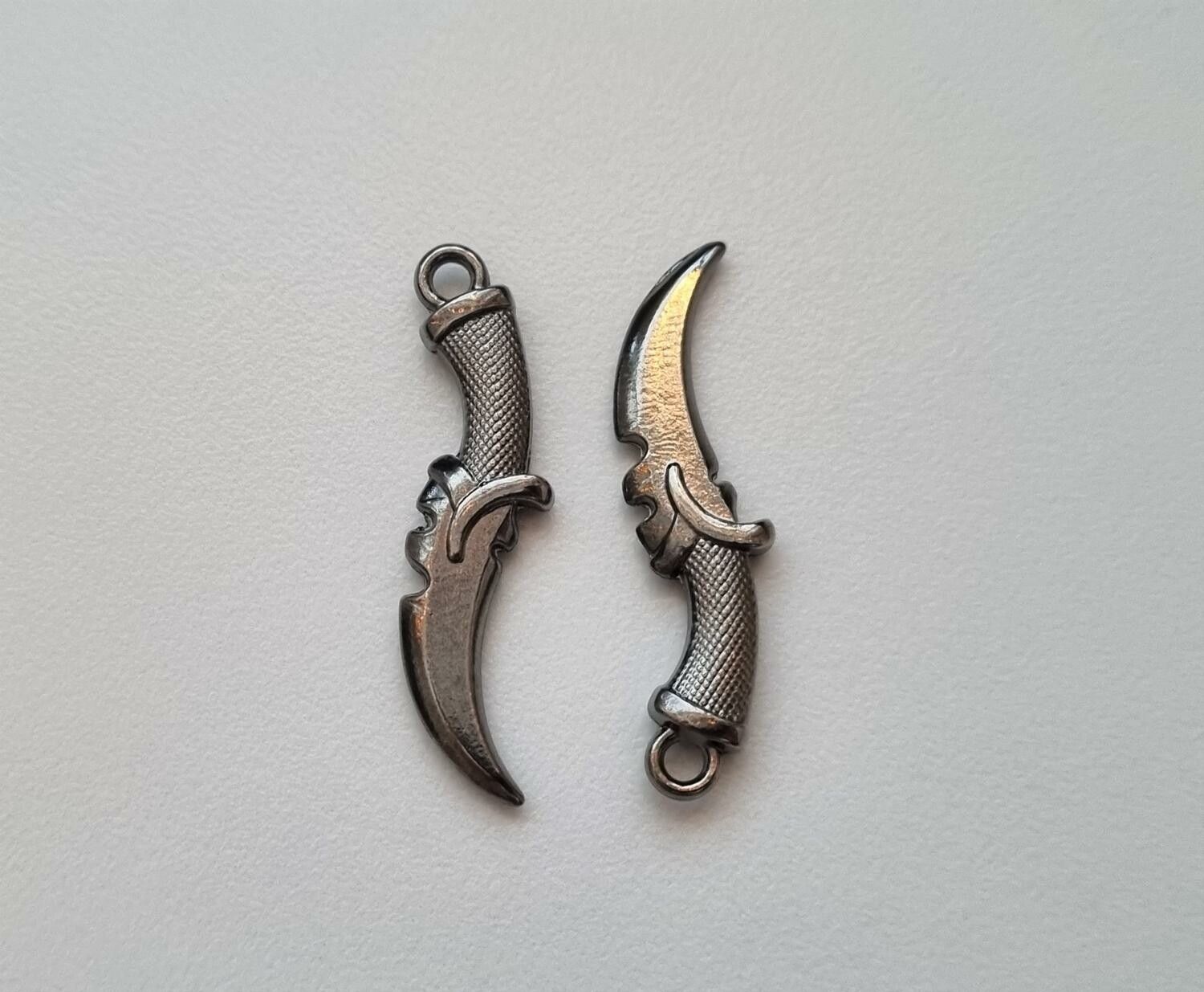 2 st silverfärgade dolkar. Berlocker / hänge / miniatyrer