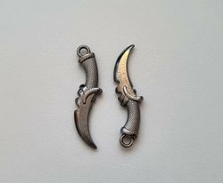 2 st silverfärgade dolkar. Berlocker / hänge / miniatyrer