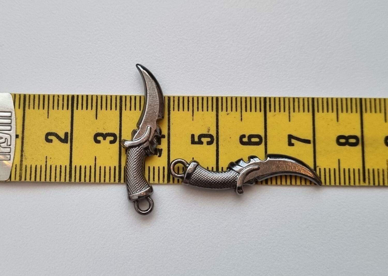 2 st silverfärgade dolkar. Berlocker / hänge / miniatyrer