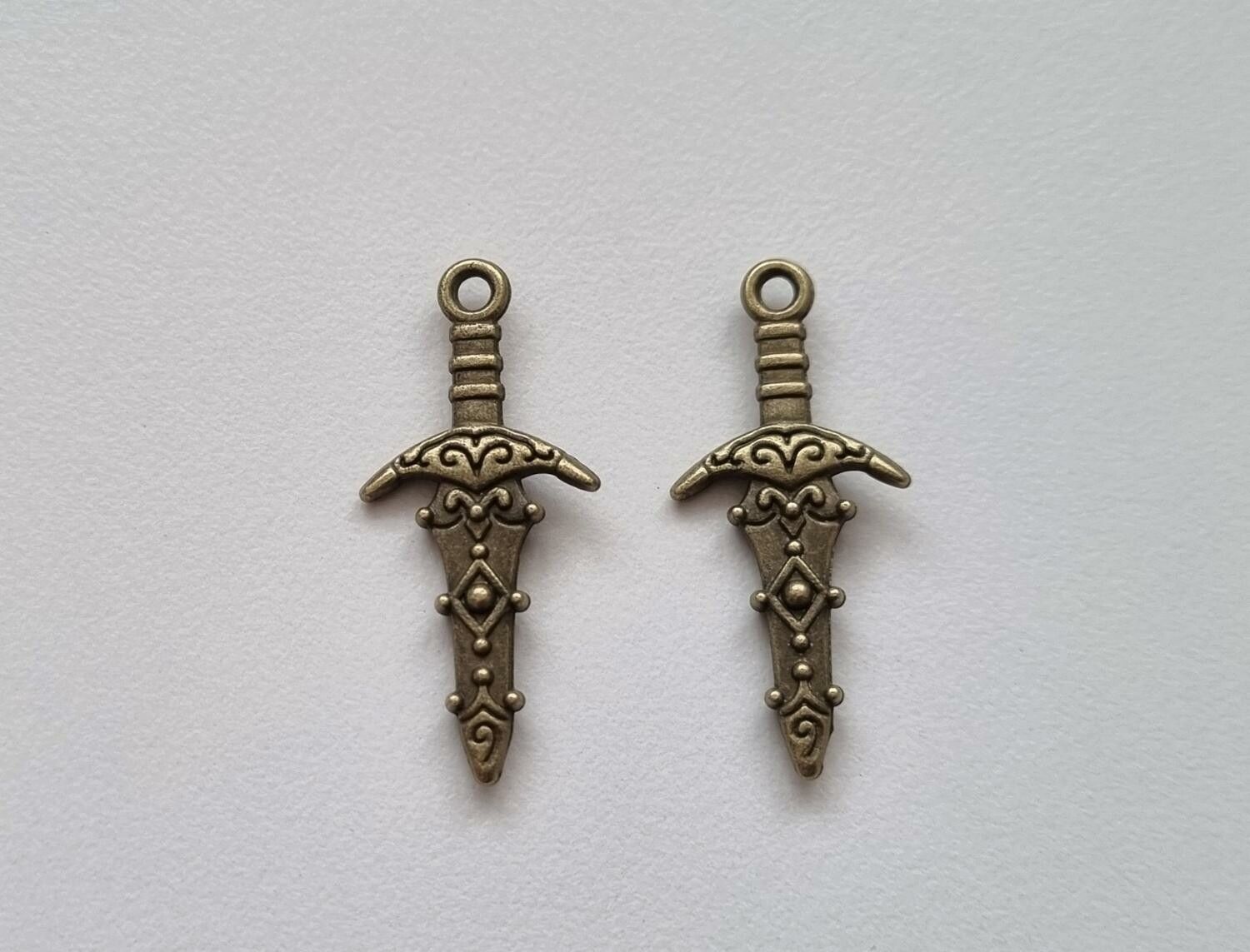 2 st små bronsfärgade svärd / minisvärd. Berlocker Charms