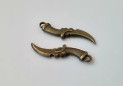 2 st bronsfärgade dolkar. Berlocker / hänge / miniatyrer