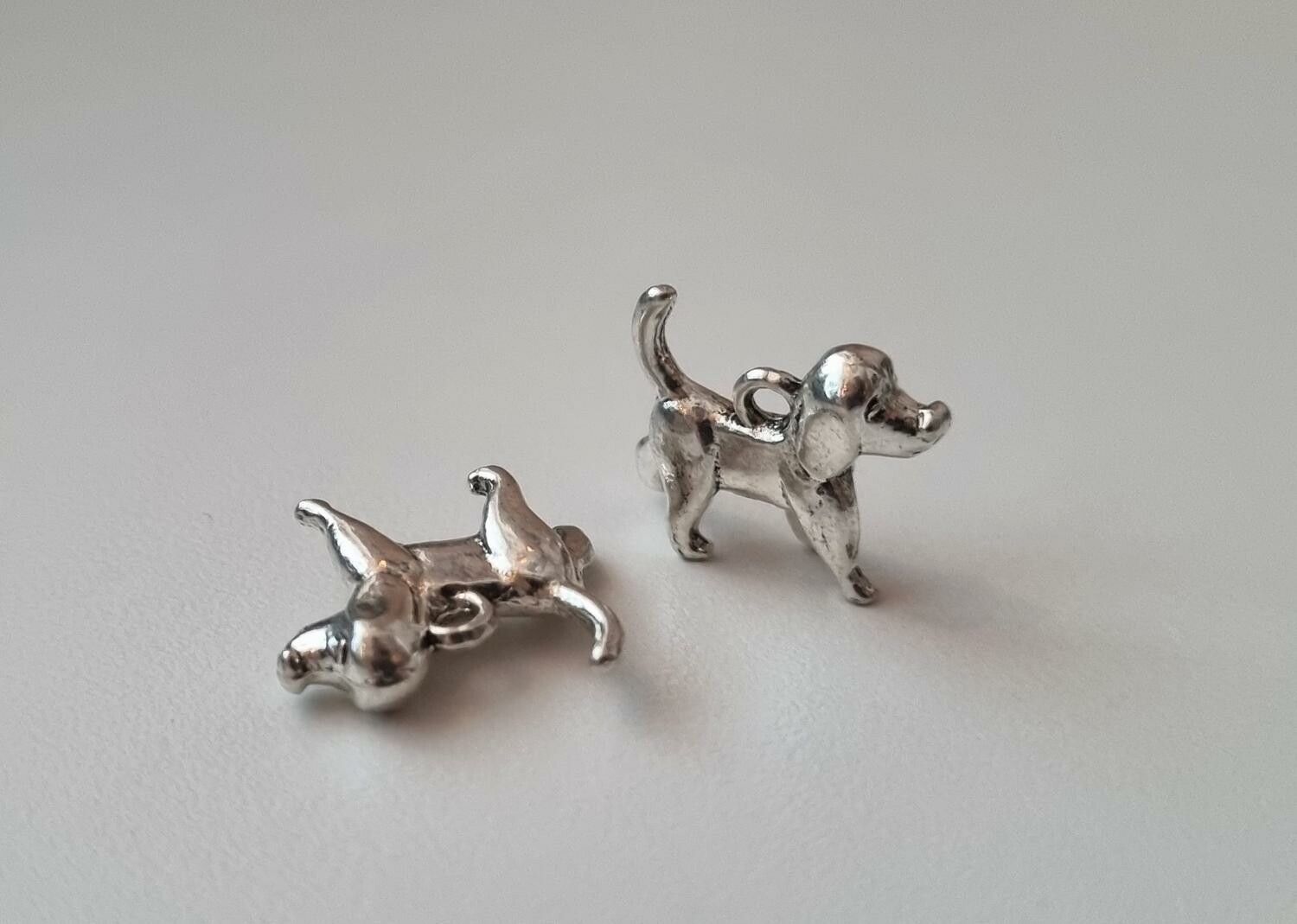 2 st silverfärgade hundar. Berlocker / charms