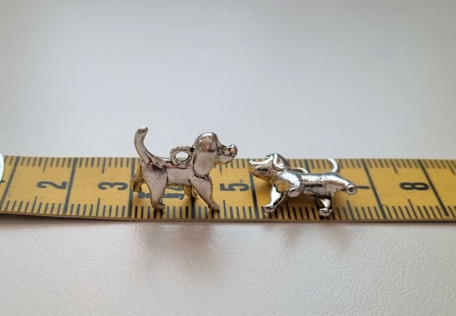 2 st silverfärgade hundar. Berlocker / charms