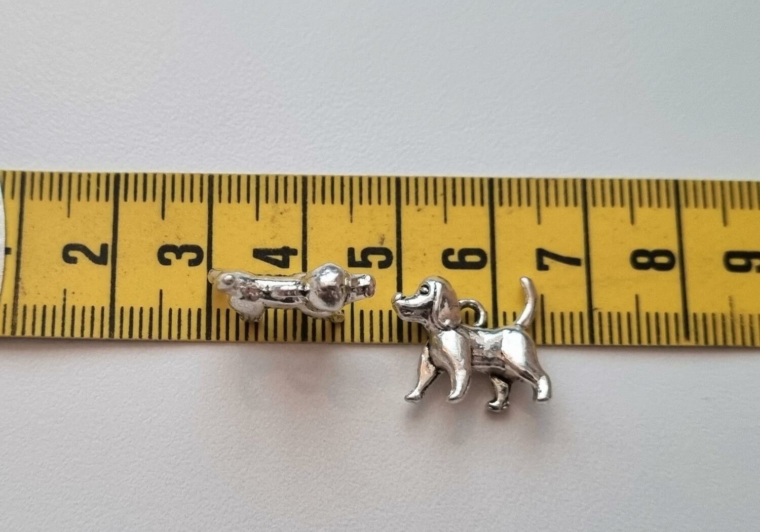 2 st silverfärgade hundar. Berlocker / charms
