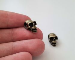 2 st bronsfärgade dödskallar. Hängen / berlocker / charms / miniatyrer