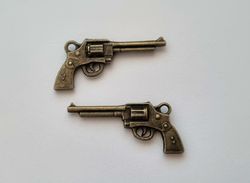 2 st bronsfärgade revolvrar / pistoler. Berlocker / charms / miniatyrer