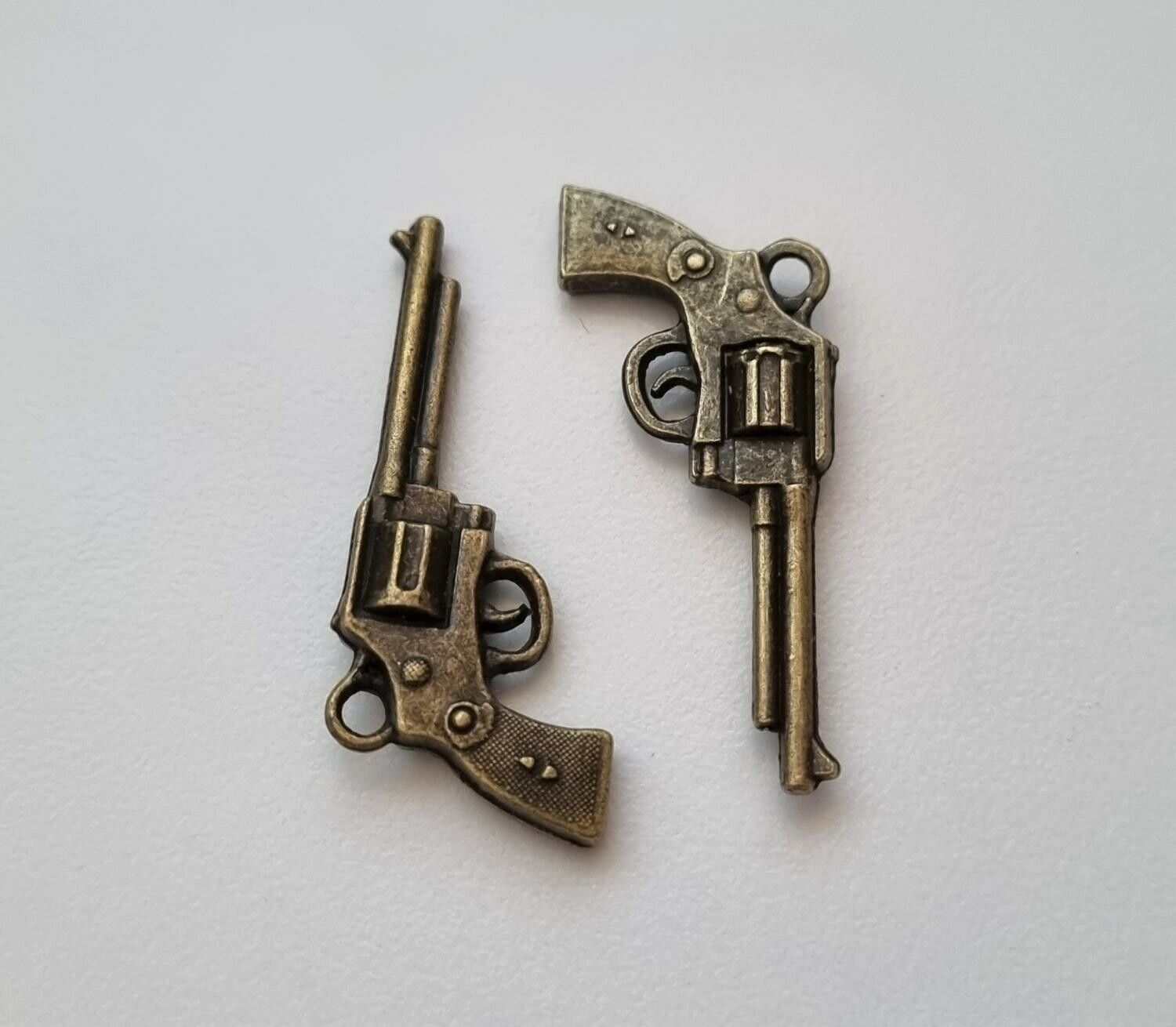 2 st bronsfärgade revolvrar / pistoler. Berlocker / charms / miniatyrer