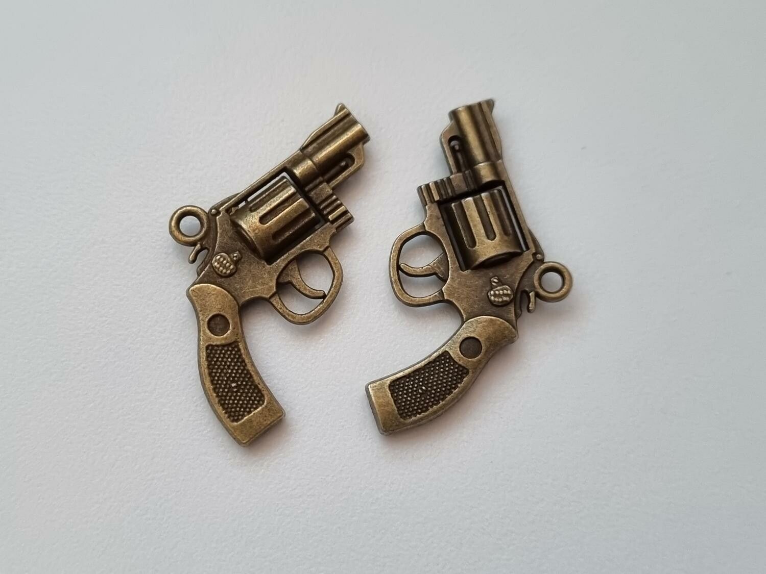 2 st bronsfärgade revolvrar / pistoler. Hängen / berlocker