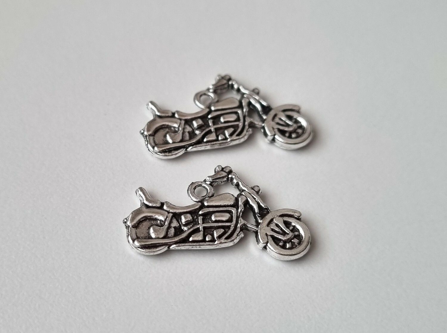 2 st silverfärgade motorcyklar, berlocker