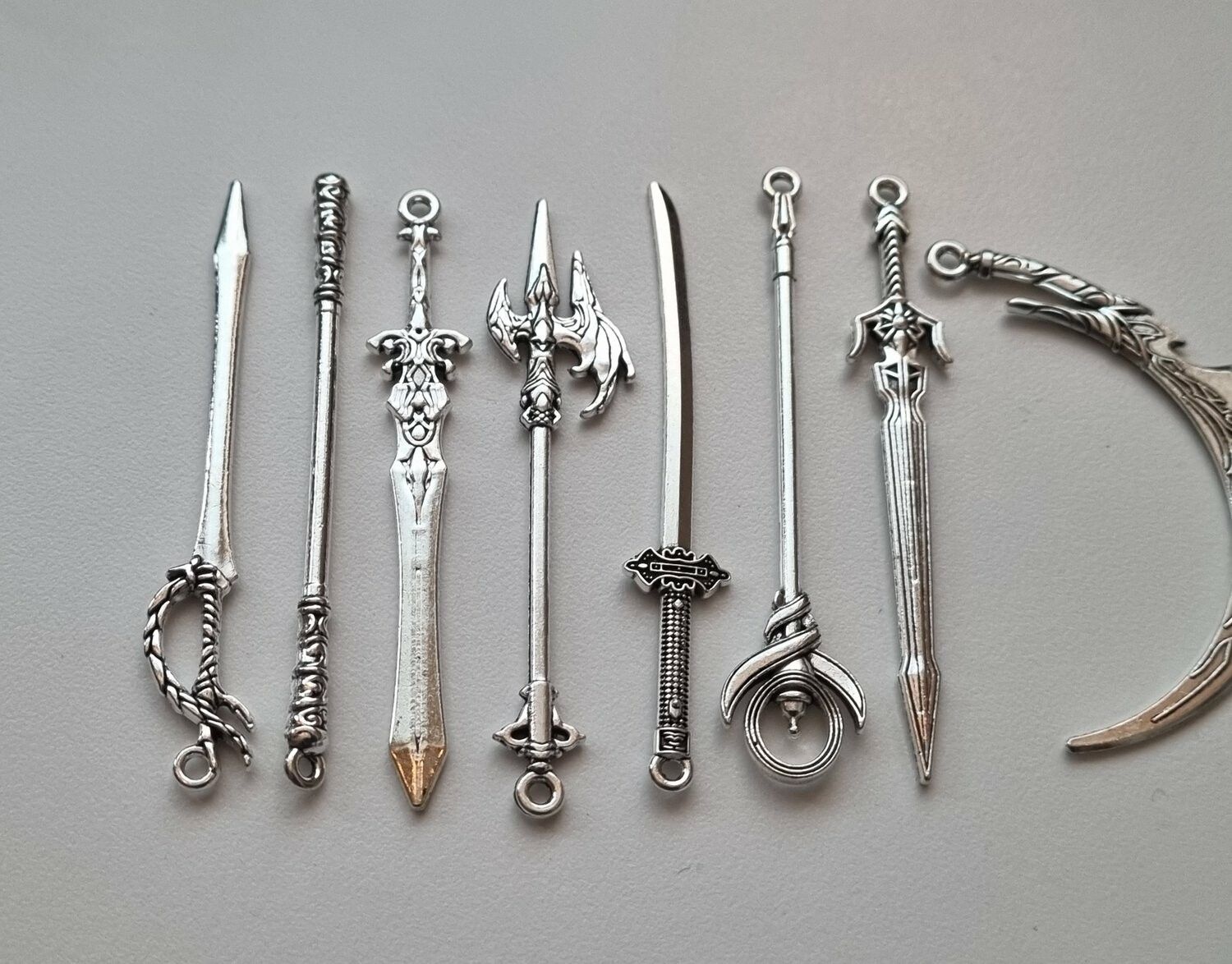10 st miniatyrvapen, minisvärd, treuddar med mera (silverfärgade)