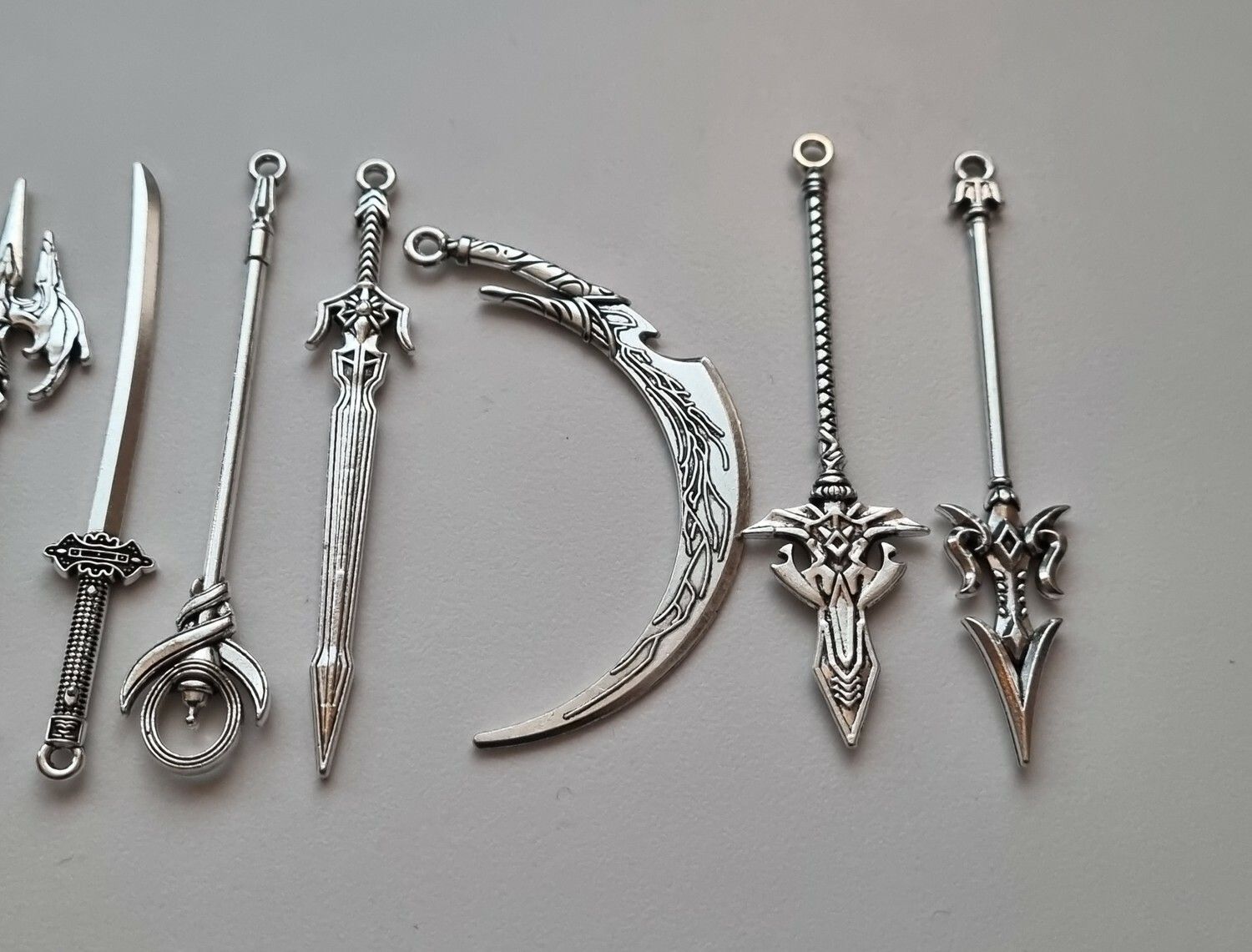 10 st miniatyrvapen, minisvärd, treuddar med mera (silverfärgade)