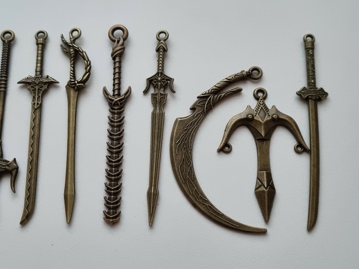 10 st berlocker - Miniatyrvapen, minisvärd, treuddar med mera (bronsfärgade)