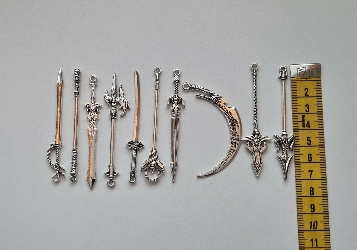 10 st miniatyrvapen, minisvärd, treuddar med mera (silverfärgade)