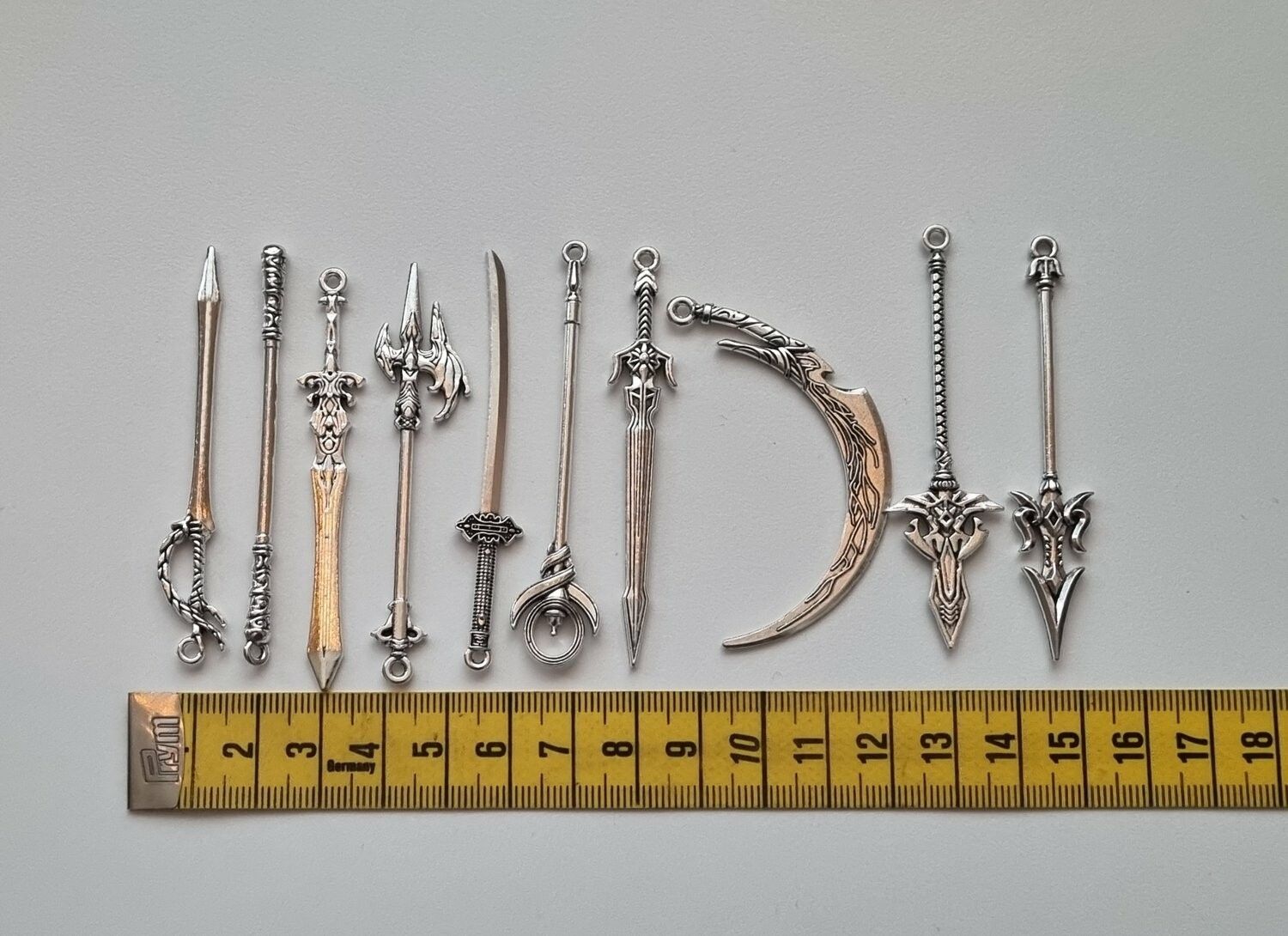 10 st miniatyrvapen, minisvärd, treuddar med mera (silverfärgade)