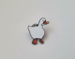 Pins, anka / gås med en kniv i munnen