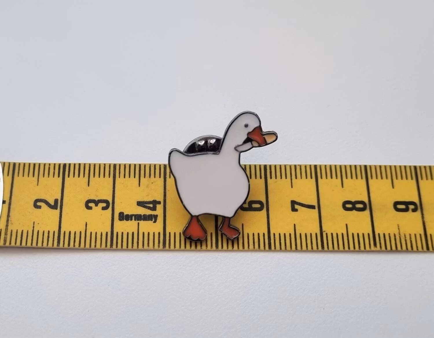 Pins, anka / gås med en kniv i munnen