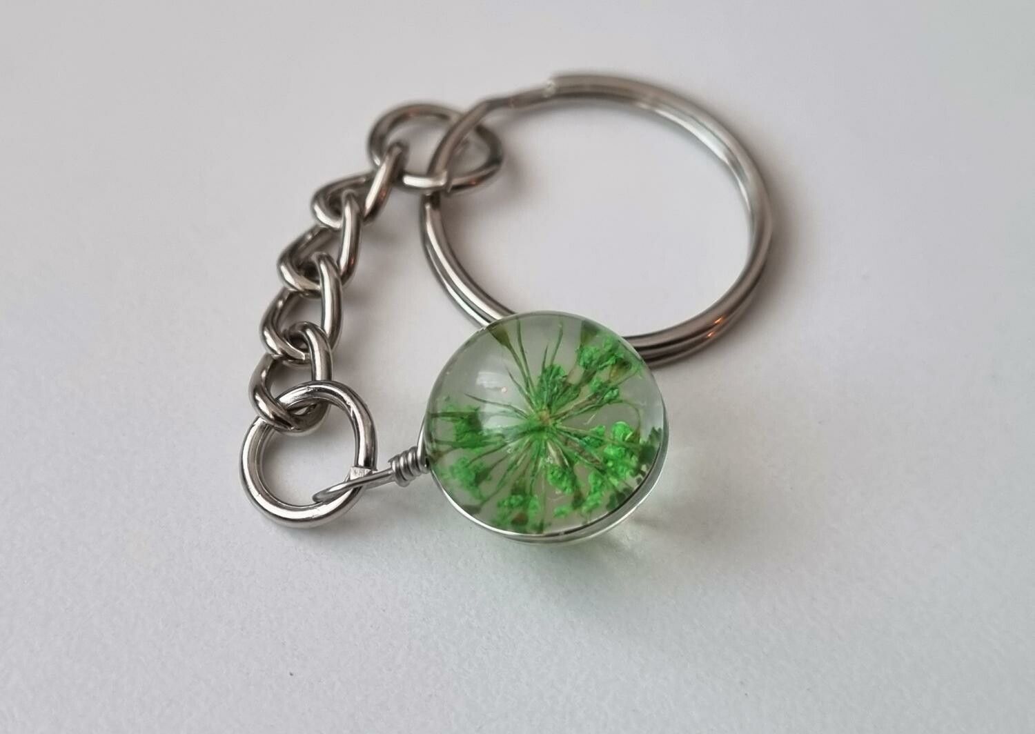 Nyckelring, rund glaskula / glasboll med torkad blomma (grön)
