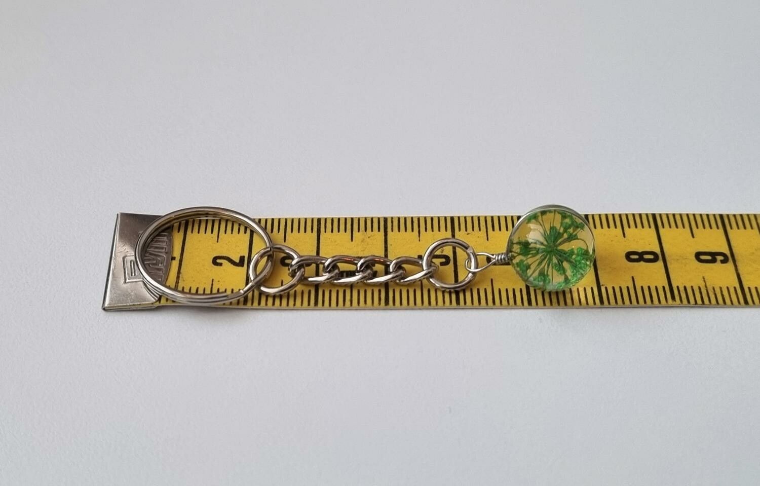 Nyckelring, rund glaskula / glasboll med torkad blomma (grön)