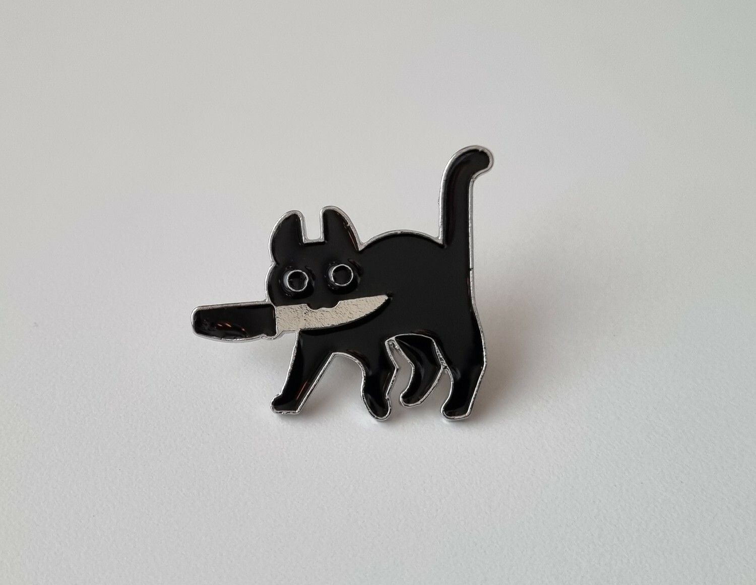 Pin, Katt med kniv i munnen
