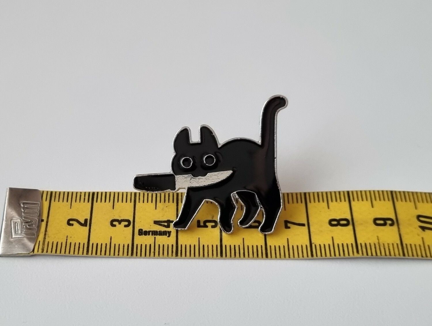 Pin, Katt med kniv i munnen