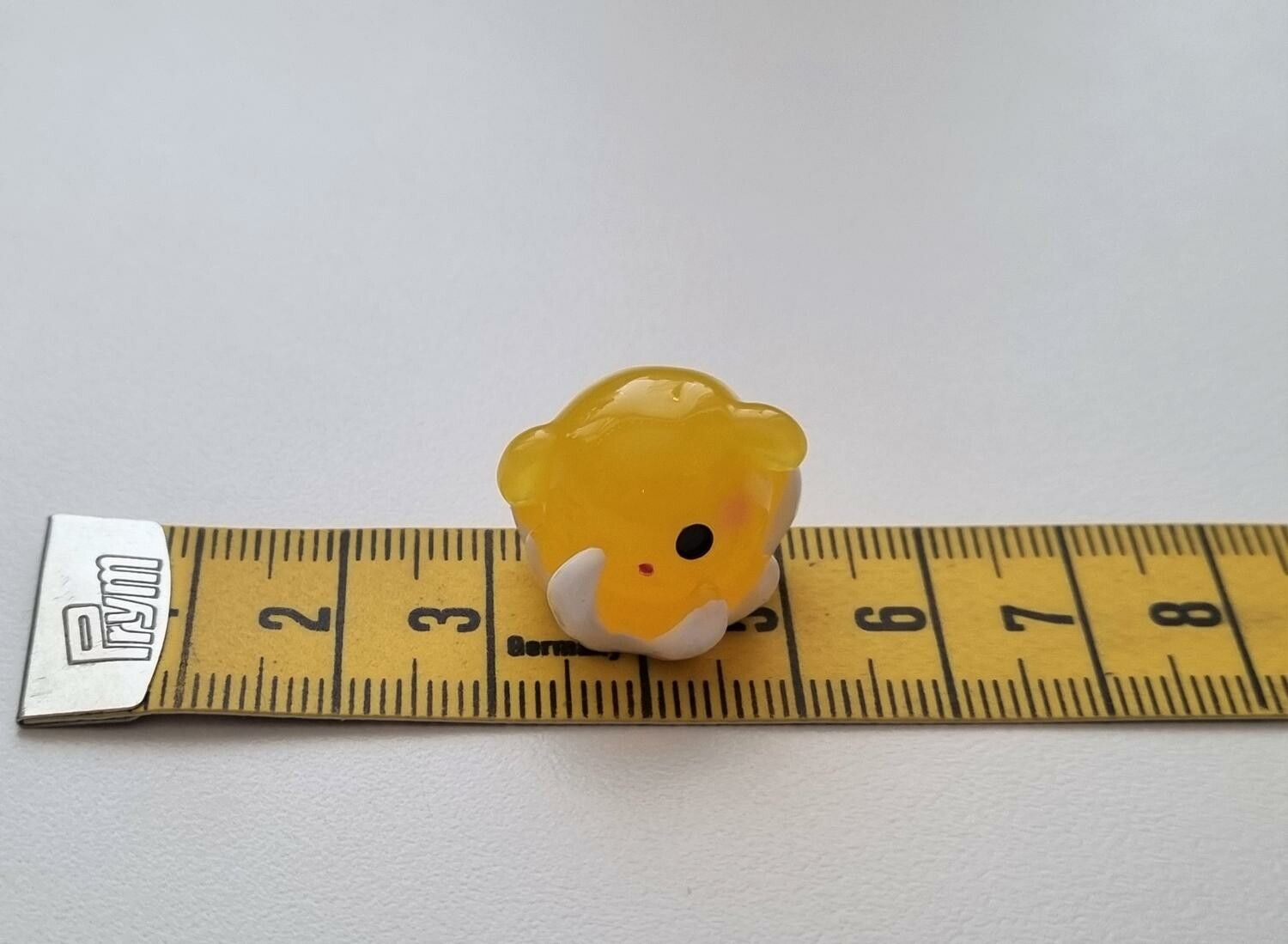 Gullig liten gul sagofigur, miniatyr