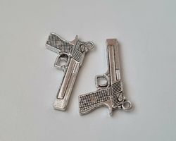 2 st silverfärgade pistoler, minipistoler, miniatyrer