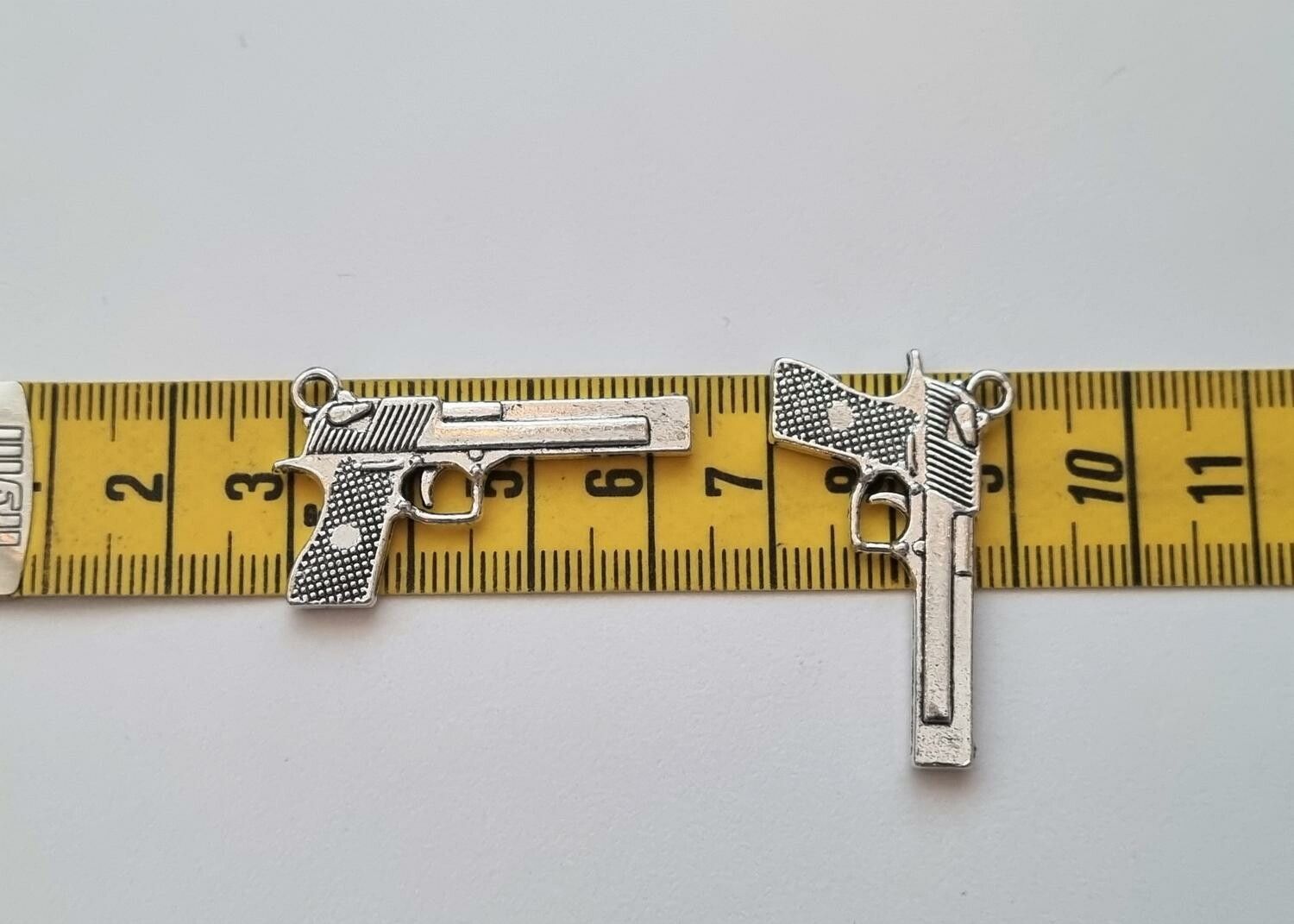 2 st silverfärgade pistoler, minipistoler, miniatyrer