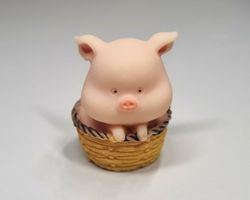 1 st liten gris, miniatyrgris i en korg