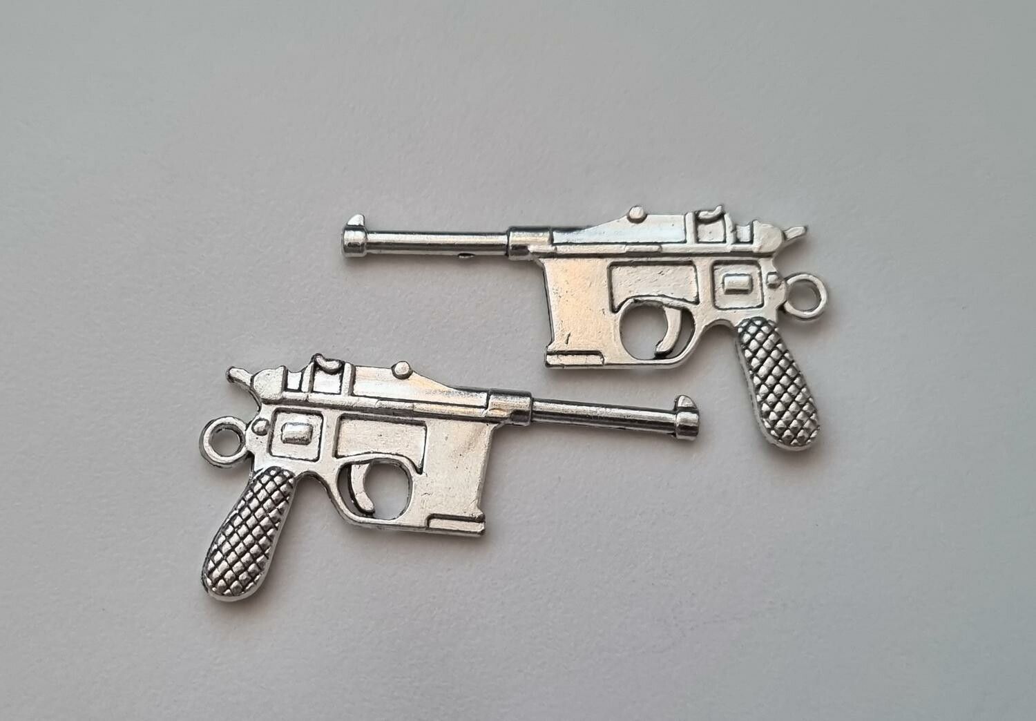 2 st silverfärgade pistoler, minipistoler, miniatyrer