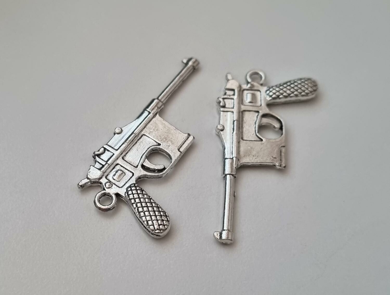 2 st silverfärgade pistoler, minipistoler, miniatyrer