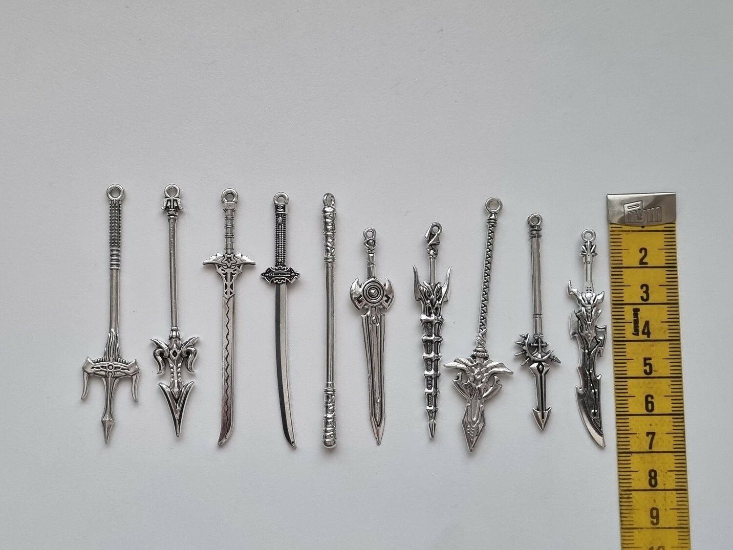 10 st berlocker - Miniatyrvapen, minisvärd, treuddar med mera