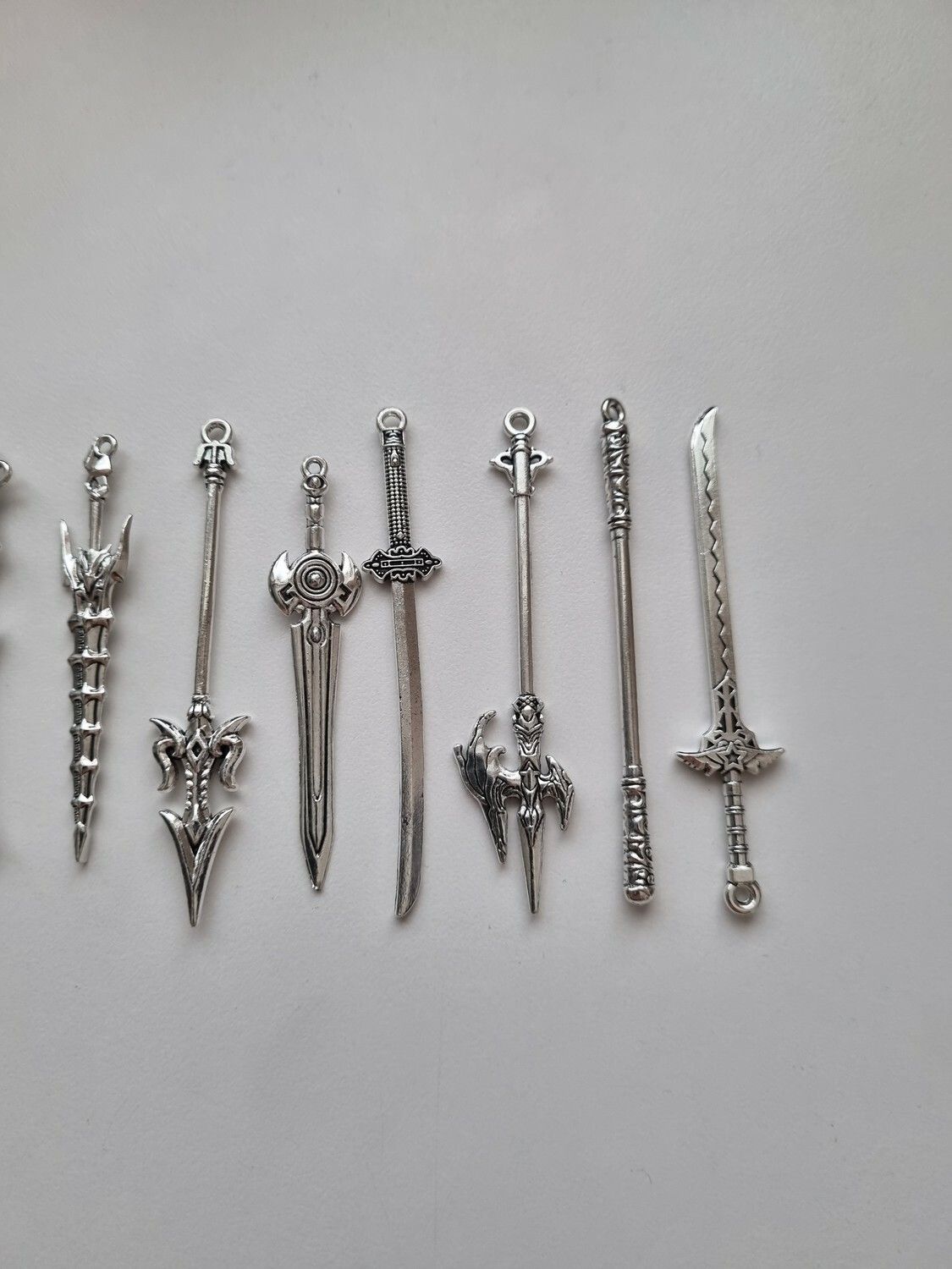 10 st berlocker - Miniatyrvapen, minisvärd, treuddar med mera