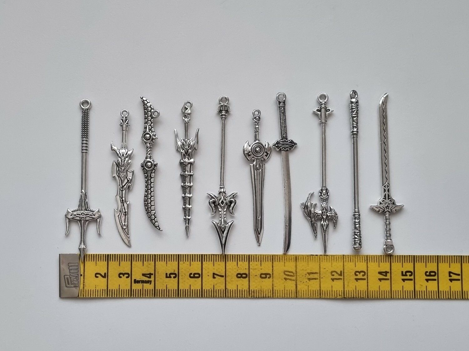 10 st berlocker - Miniatyrvapen, minisvärd, treuddar med mera