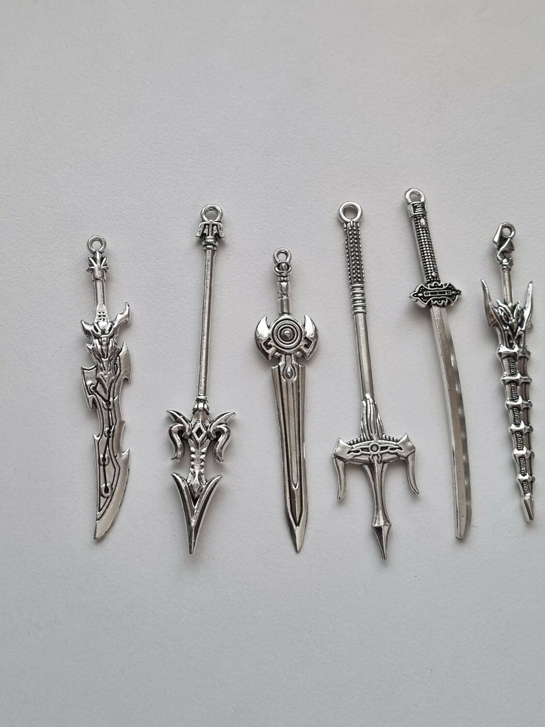 10 st berlocker - Miniatyrvapen, minisvärd, treuddar med mera