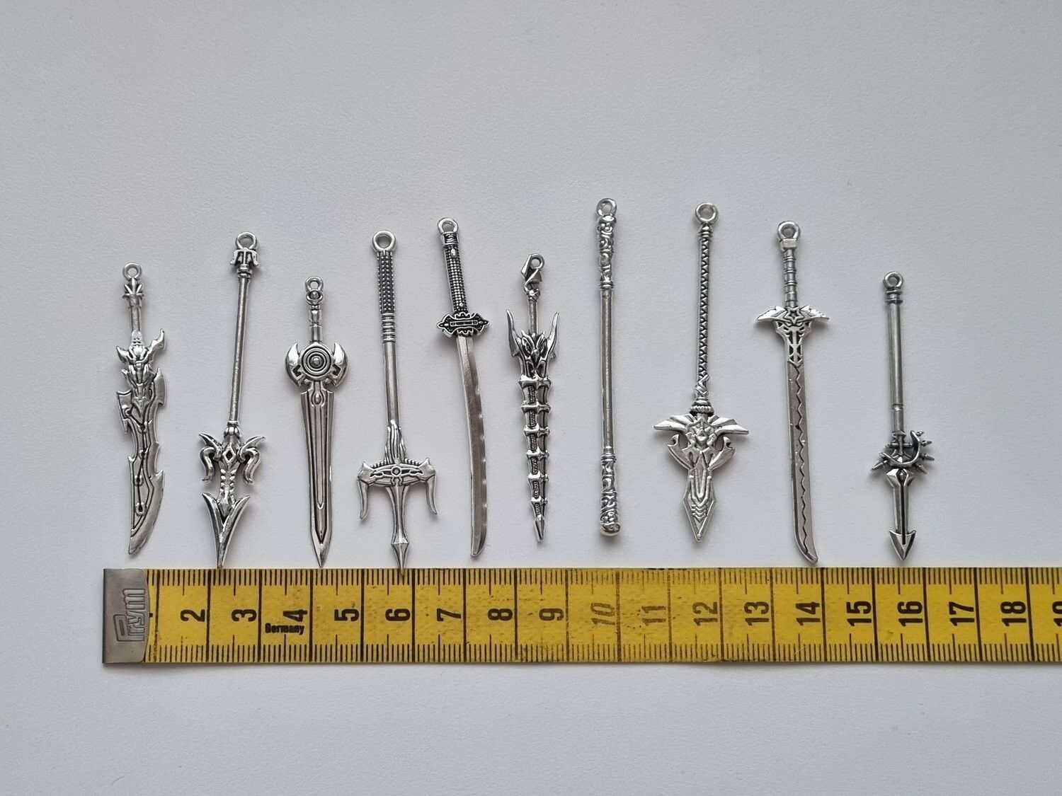 10 st berlocker - Miniatyrvapen, minisvärd, treuddar med mera