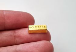 1 st leksakspeng / låtsaspeng som föreställer en guldtacka, miniatyr