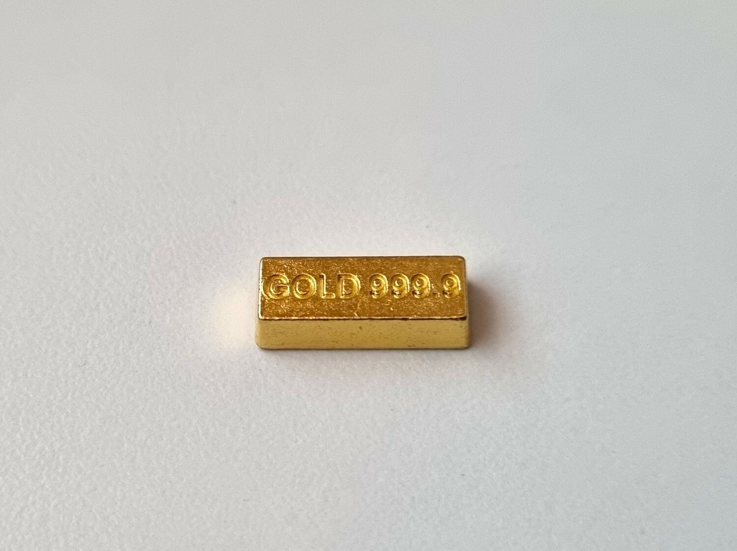 1 st leksakspeng / låtsaspeng som föreställer en guldtacka, miniatyr