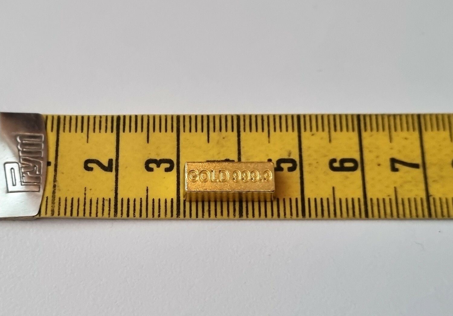 1 st leksakspeng / låtsaspeng som föreställer en guldtacka, miniatyr