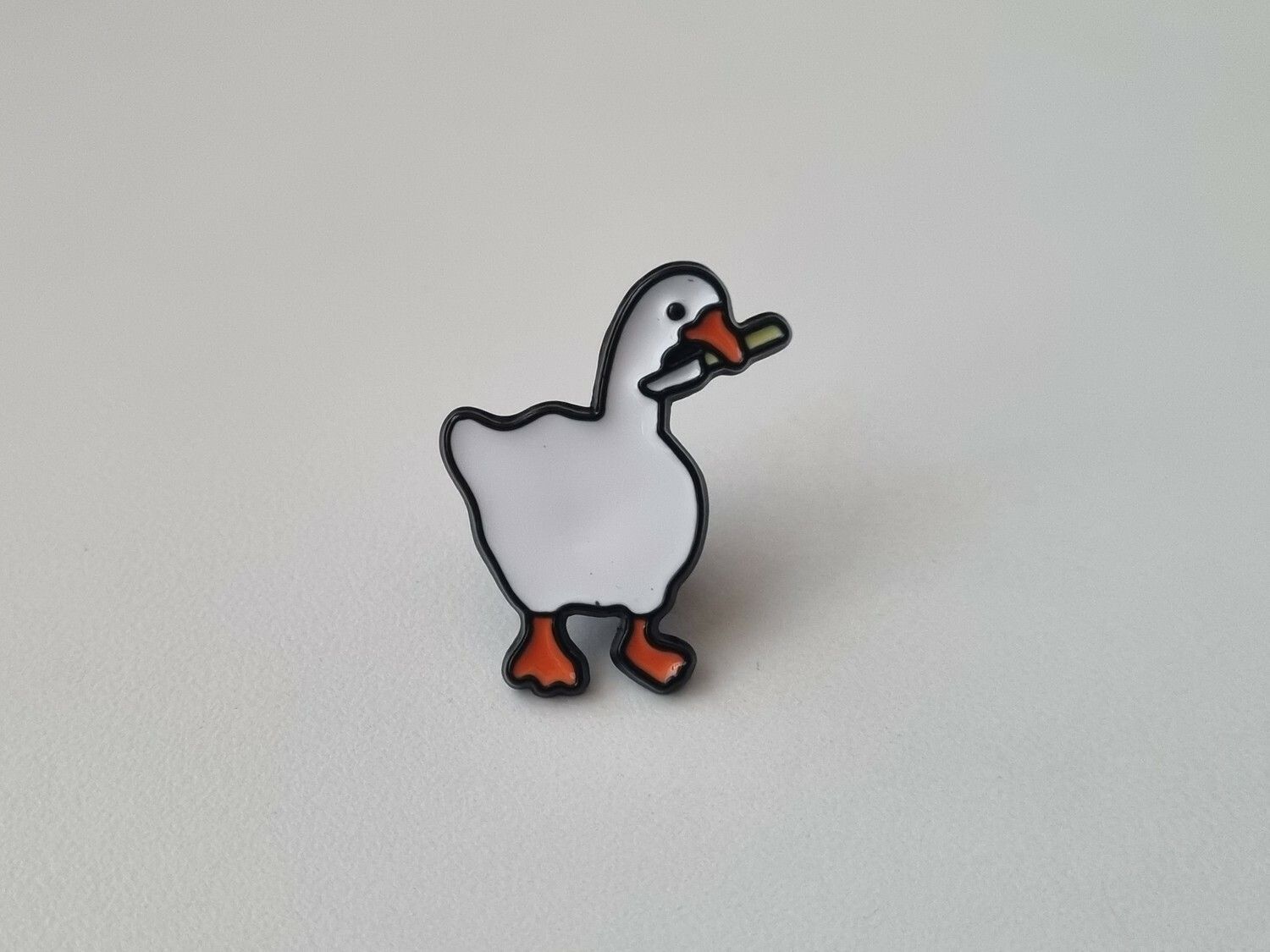 Pins, anka / gås med en kniv i munnen