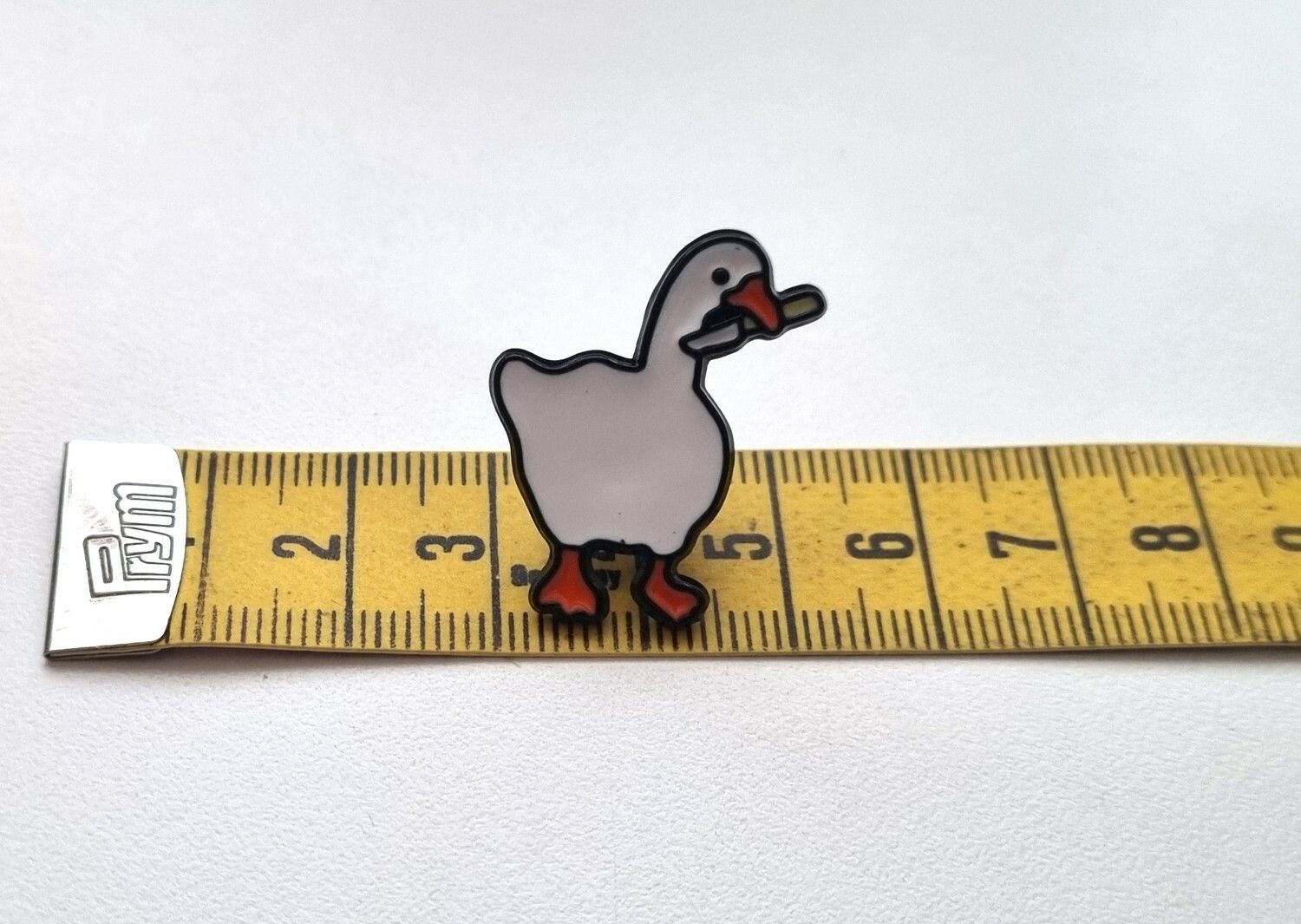Pins, anka / gås med en kniv i munnen