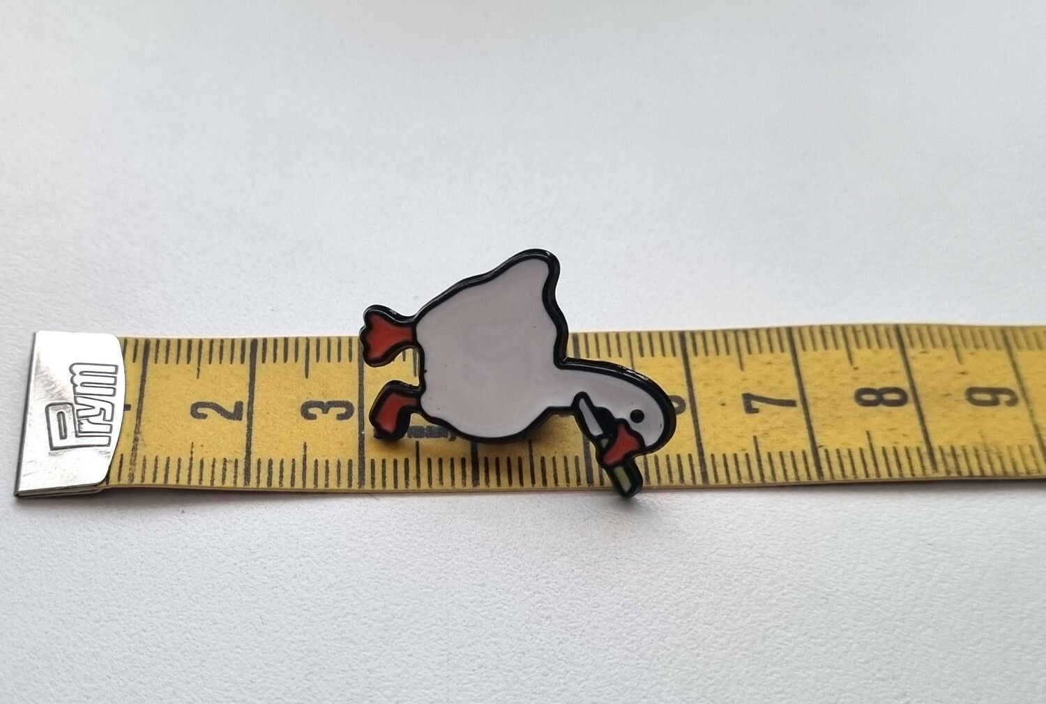 Pins, anka / gås med en kniv i munnen