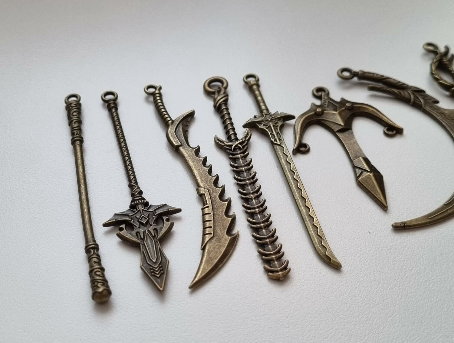10 st berlocker - Miniatyrvapen, minisvärd, treuddar med mera (bronsfärgde)