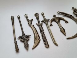 10 st berlocker - Miniatyrvapen, minisvärd, treuddar med mera (bronsfärgde)