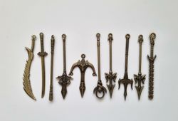 10 st berlocker - Miniatyrvapen, minisvärd, treuddar med mera (bronsfärgade)