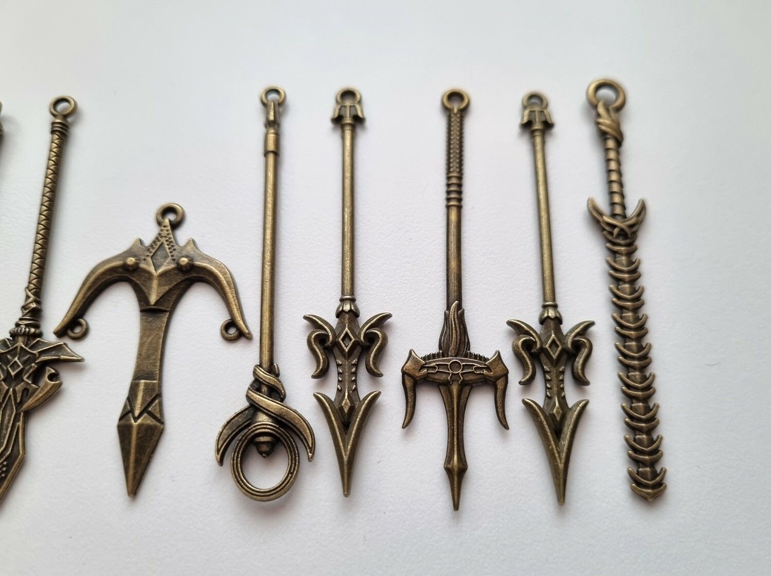 10 st berlocker - Miniatyrvapen, minisvärd, treuddar med mera (bronsfärgade)