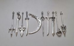 10 st berlocker - Miniatyrvapen, minisvärd, treuddar med mera (silverfärgade)