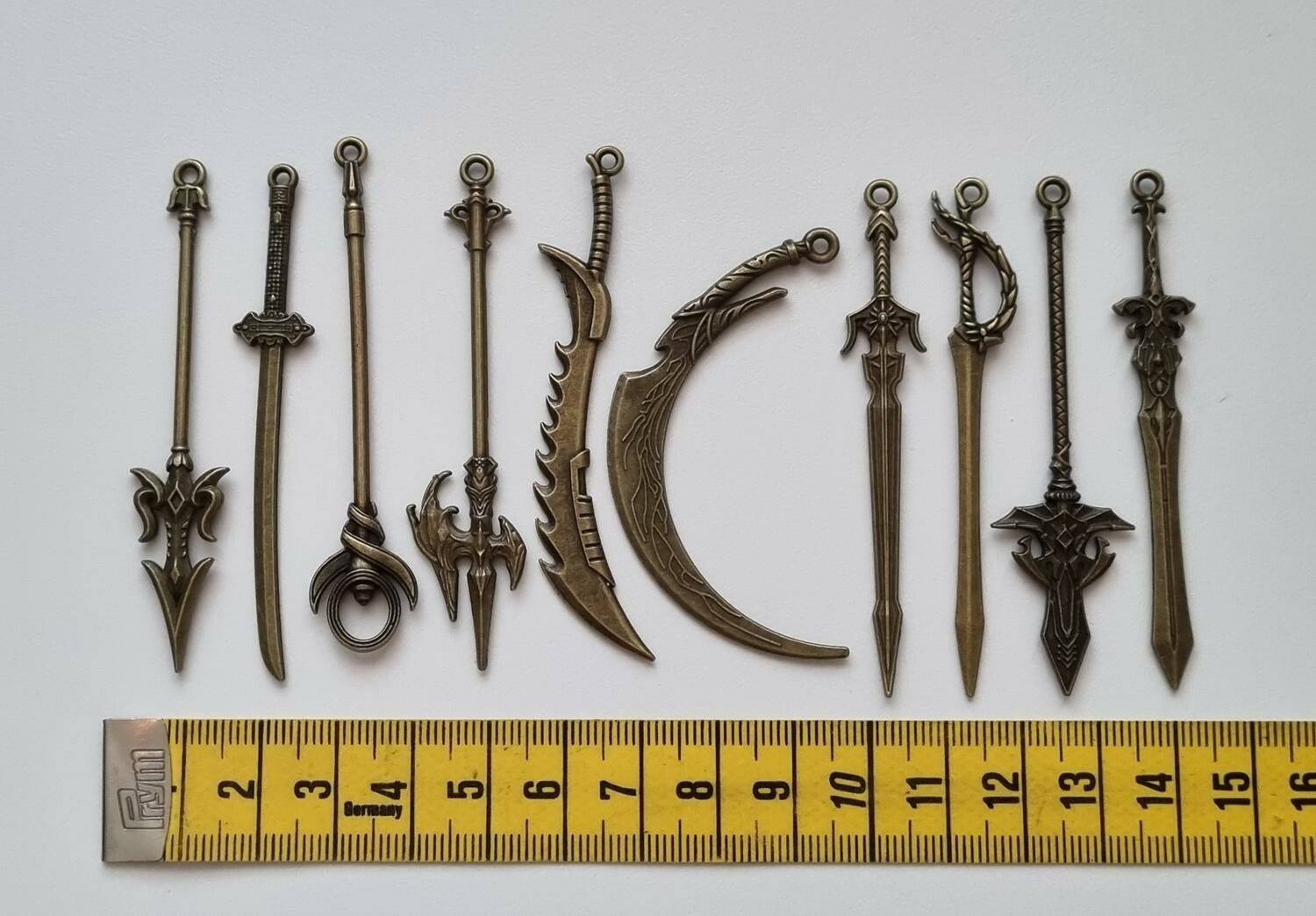 10 st berlocker - Miniatyrvapen, minisvärd, treuddar med mera (bronsfärgade)
