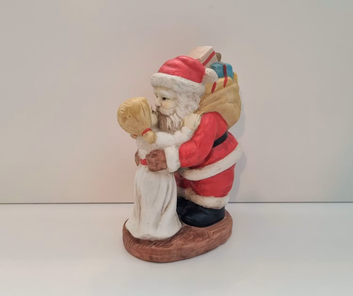 Handmålad figurin, jultomte som pussar flicka (580 gram)