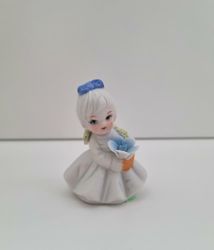 Söt liten figurin, flicka som håller i en blombukett
