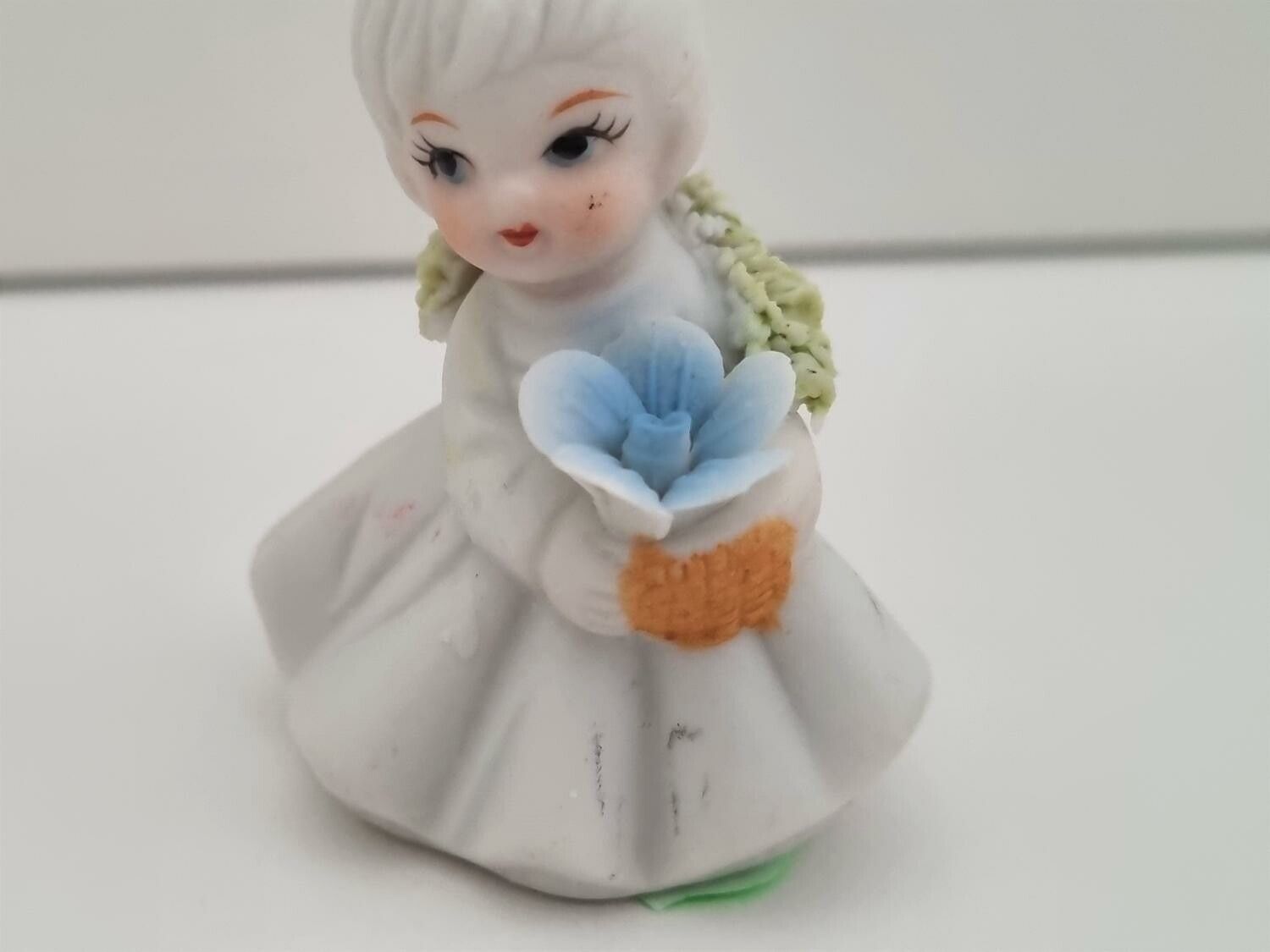 Söt liten figurin, flicka som håller i en blombukett